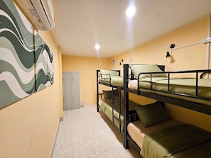A dormitory room with bunk beds, a wardrobe, and a wall-mounted air conditioner. - Ubuntu Live Boutique Hostel & Rooms (Phuket)
