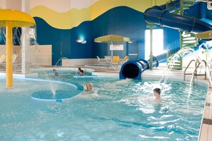 An indoor swimming pool with multiple lanes, water slides, and a children's play area. - Residence Inn Winnipeg (Winnipeg)