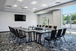 A conference room with a large table, chairs, a flat-screen TV, and a carpeted floor. - Residence Inn Winnipeg (Winnipeg)