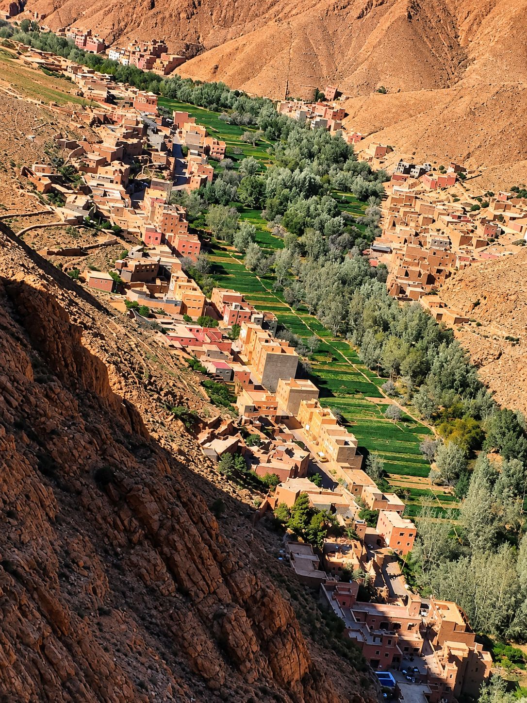 Un pueblo en terrazas con arquitectura tradicional, ubicado en un paisaje montañoso.