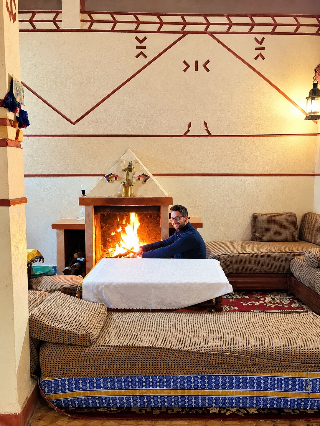 Una habitación con chimenea, un sofá y un tapete estampado.