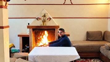 Una habitación con chimenea, un sofá y un tapete estampado.