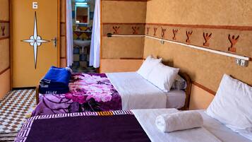 Une chambre d’hôtel avec deux lits, une salle de bain avec un lavabo et une porte portant le numéro 6.