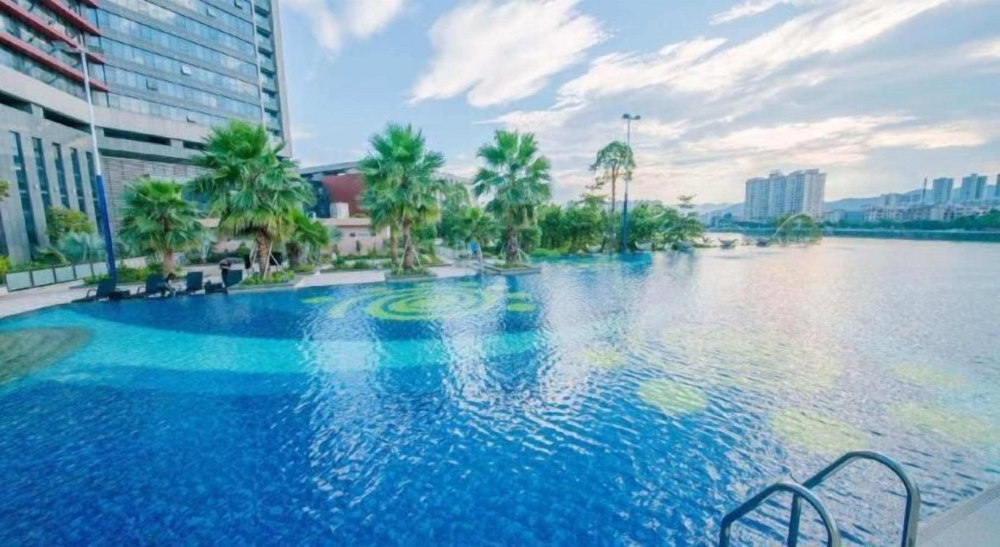A swimming pool with a clear view of the surrounding buildings and palm trees.