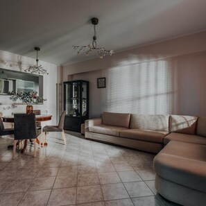 Una sala de estar con sofá, sillas, una mesa de comedor y un aparador.