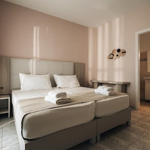 A hotel room with a large bed, a bedside table, and a wall-mounted clock. - Dream Hotel (Zakynthos)