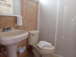 A bathroom with a sink, toilet, and shower. - Hotel Posada de Abril (Santa María Huatulco)