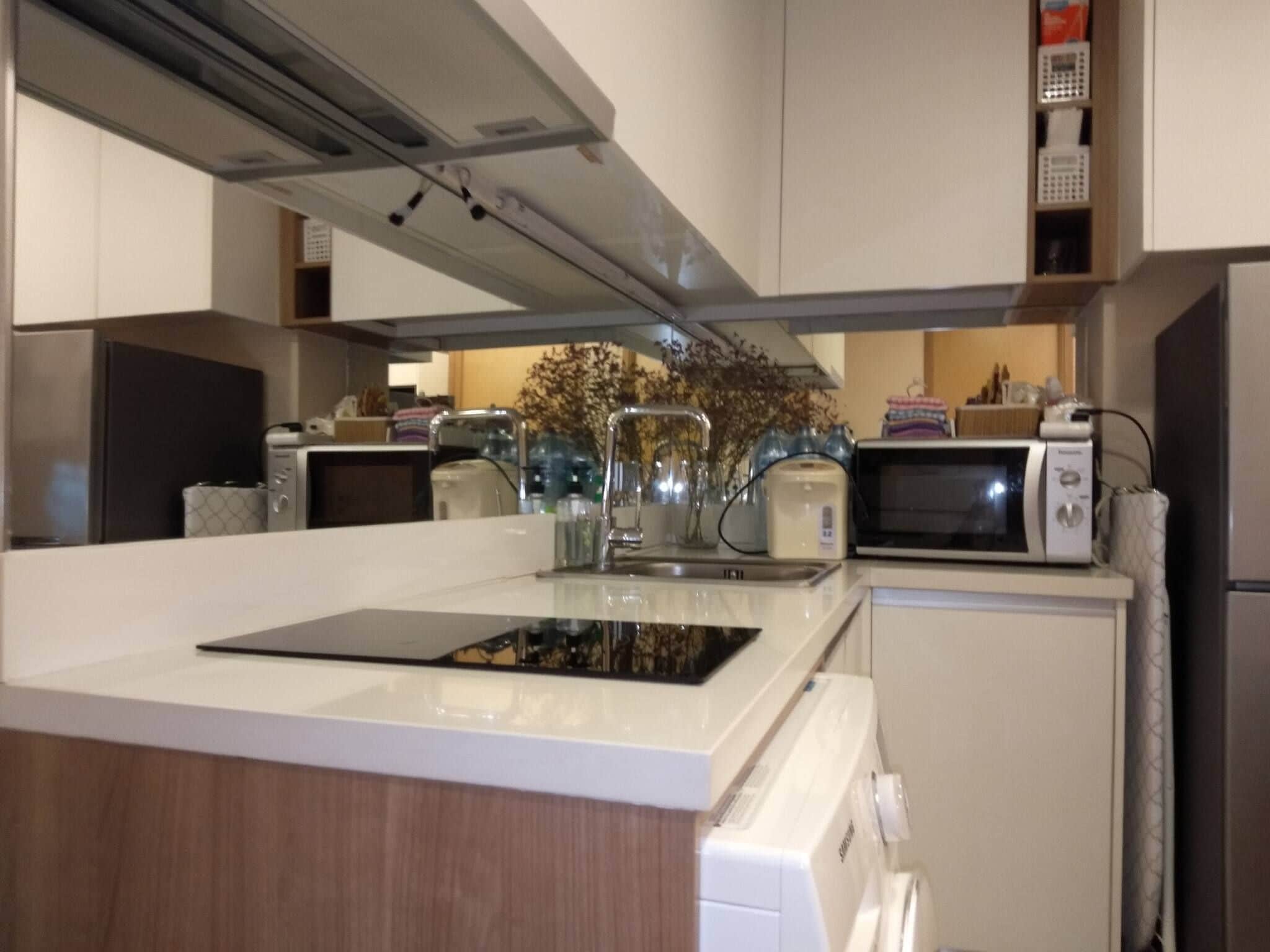 A modern kitchen with a central island, built-in microwave, and stainless steel appliances.