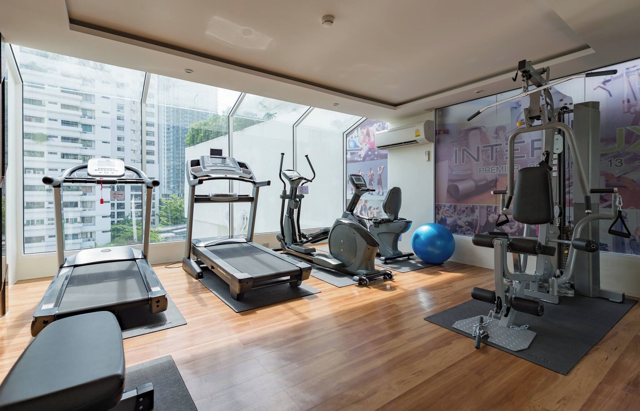 A gym with cardio machines, a rowing machine, and a blue exercise ball.