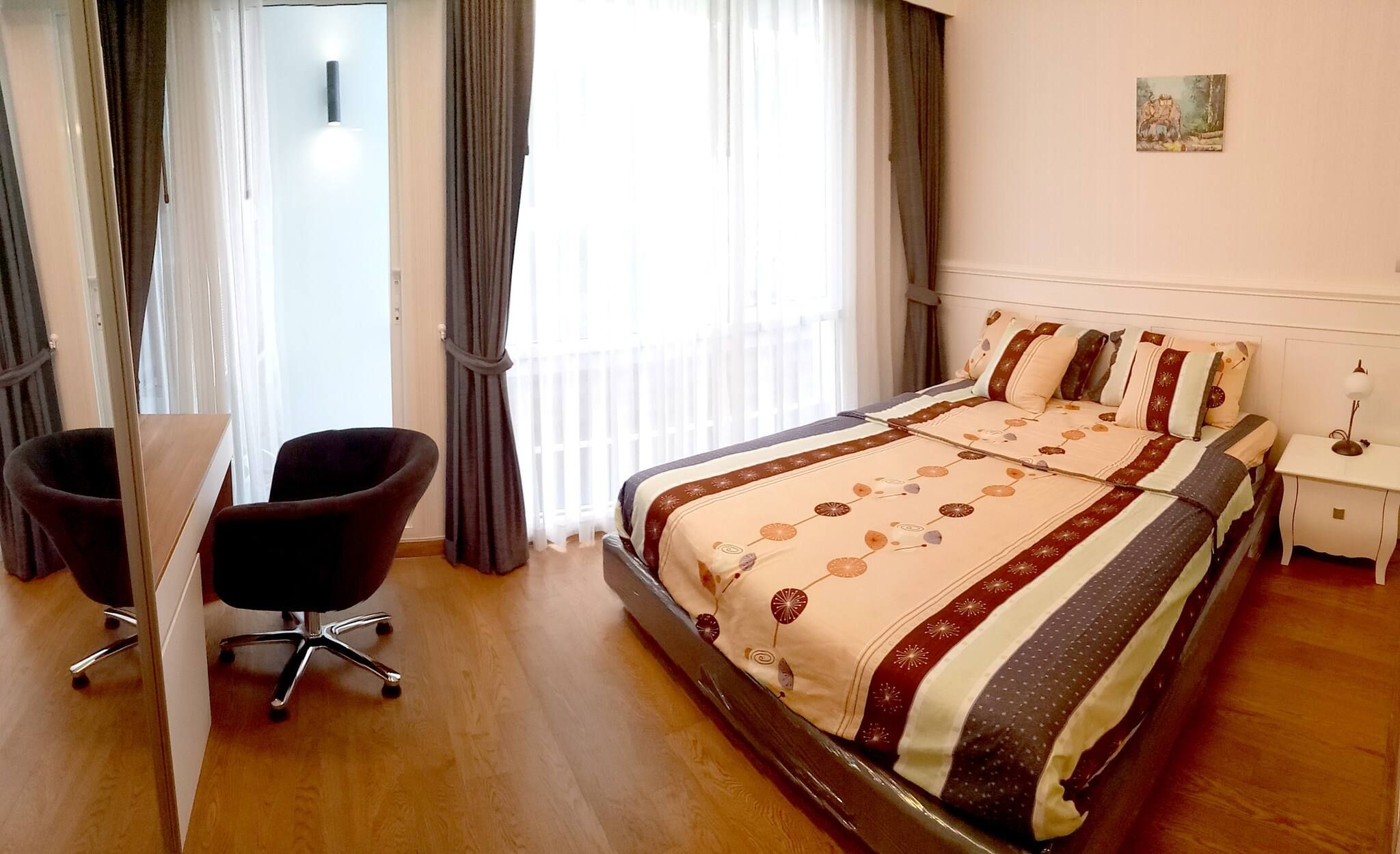 A hotel room with a bed, a desk, and a chair.
