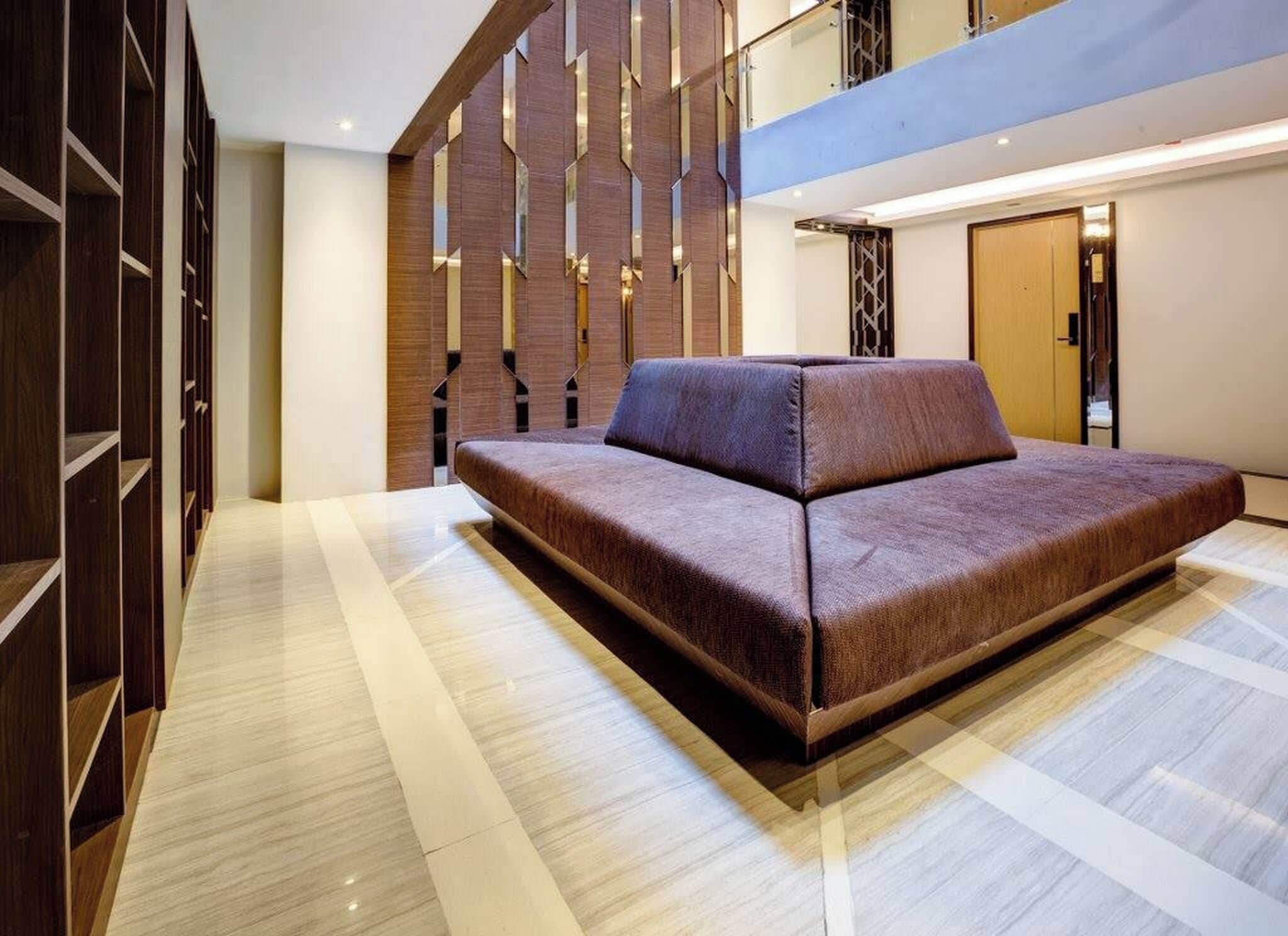 A modern interior with a sofa, wooden paneling, and a checkered floor.
