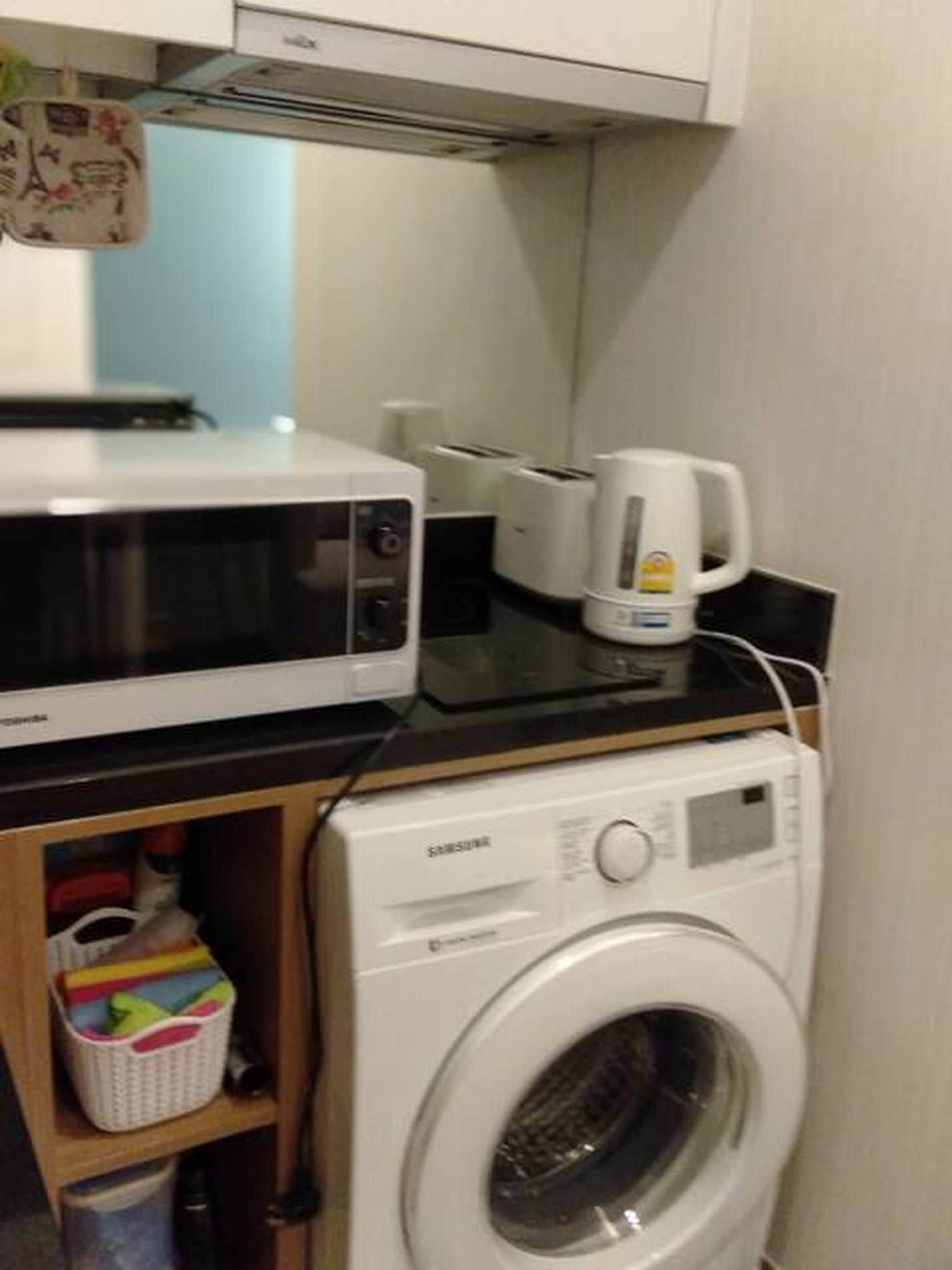 A compact kitchen with a microwave, toaster, and coffee maker on the countertop.