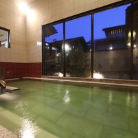 Una piscina con vistas a edificios al anochecer.