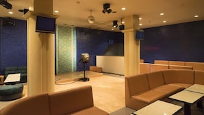 Une salle équipée de sièges, d’une scène et d’un projecteur.