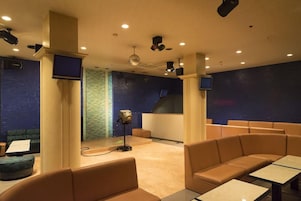 Una sala con asientos, un escenario y un proyector.
