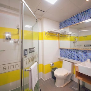 A bathroom with a glass shower enclosure, a toilet, a sink, and a mirror with a blue-tiled backsplash. - 7 Days Inn Shenzhen Guomao Metro Station (Shenzhen)