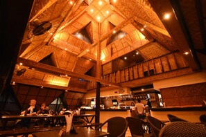 An interior with a high, vaulted ceiling featuring intricate woodwork and multiple skylights. - Pyramid Alona (Panglao)