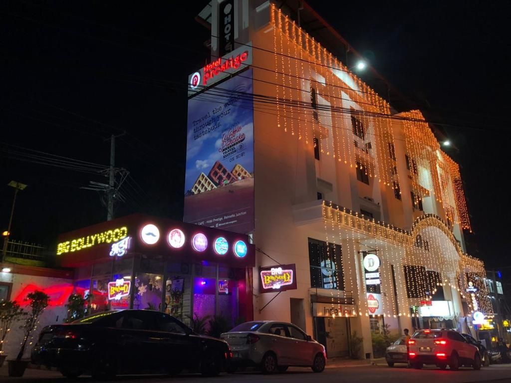 A hotel with multiple signs, including 'Hotel Prestige' and 'Big Hollywood.'