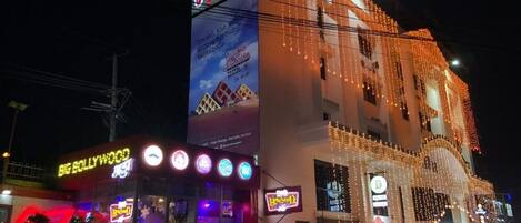 A hotel with multiple signs, including 'Hotel Prestige' and 'Big Hollywood.'