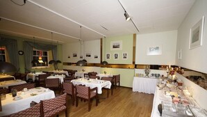 A restaurant with multiple tables and chairs, a buffet line, and framed pictures on the walls. - Md-rabe's Hotel Kiel (Kiel)