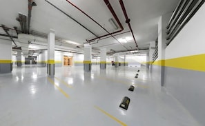 A spacious indoor parking area with clear markings on the floor, pillars, and walls. - Aswar Hotel Riyadh (Riyadh)