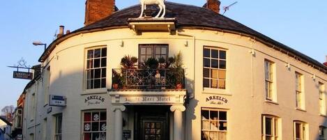 A traditional building with a sign for 'Arkell's' and a horse statue on the roof.