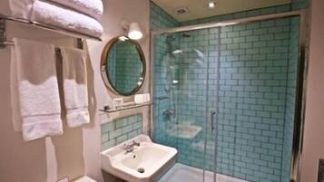 Une salle de bain avec une douche à parois de verre, un lavabo et un miroir.