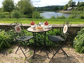 A round table with a floral design, surrounded by four chairs with similar patterns.