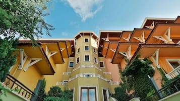 A multi-story hotel with balconies and a central entrance.
