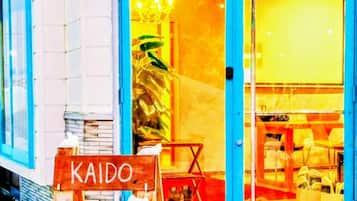 A storefront with a sign reading 'KAIDO URASA' and a blue door.