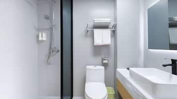 A modern bathroom with a shower, toilet, and sink.