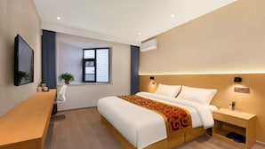 Ein Hotelzimmer mit Bett, Nachttisch und einem Fenster mit Blick.