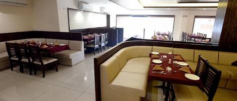 A dining area with a booth seating arrangement and a separate dining table with chairs.