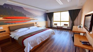 A hotel room with a bed, a desk, a chair, a television, and a large window with curtains. - Thank Inn Plus Hotel Shandong Zaozhaung Xuecheng District Wanda Plaza (Zaozhuang)