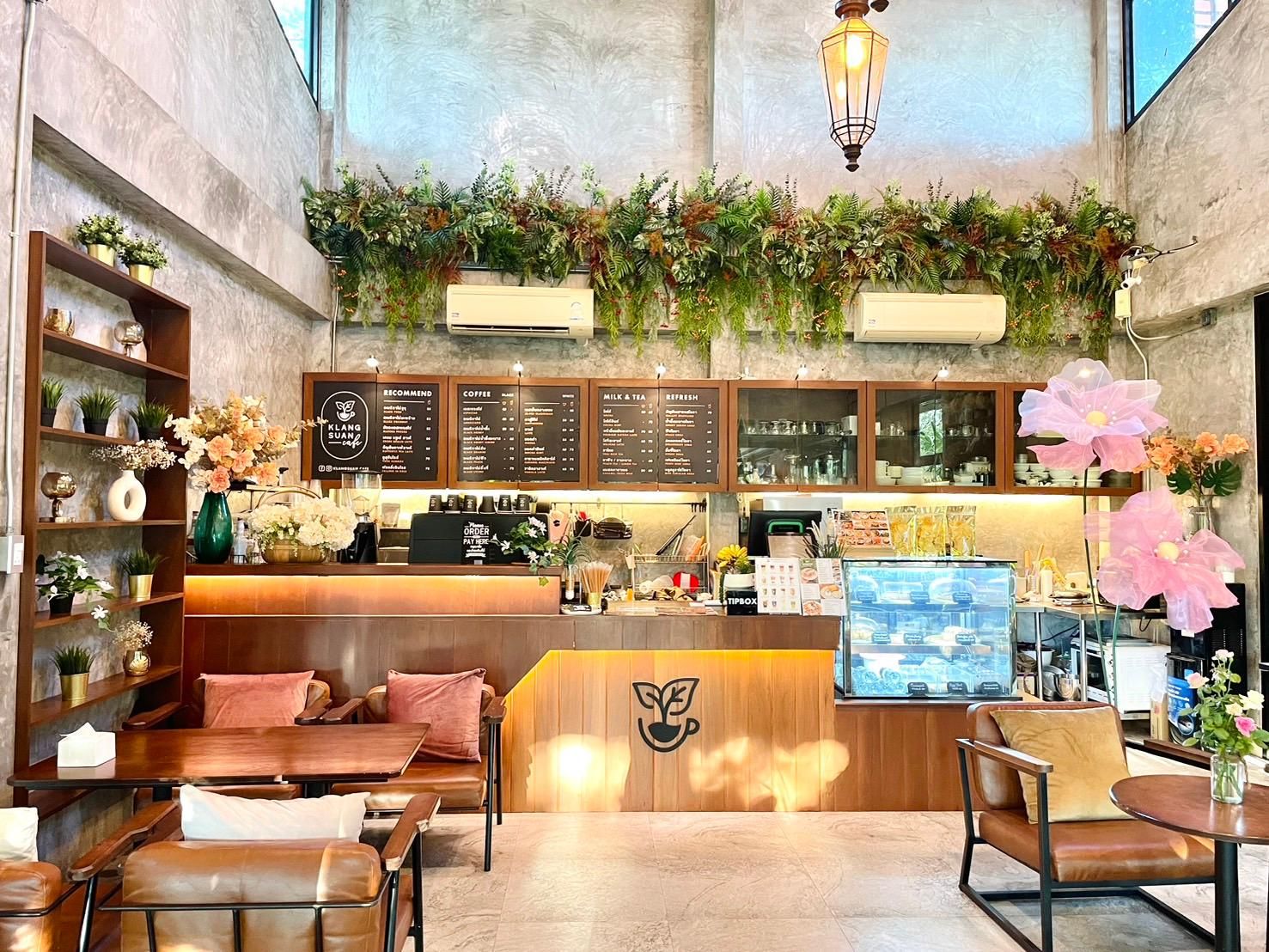 A coffee shop interior with a wooden counter, seating area, and menu boards.