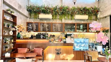 A coffee shop interior with a wooden counter, seating area, and menu boards.