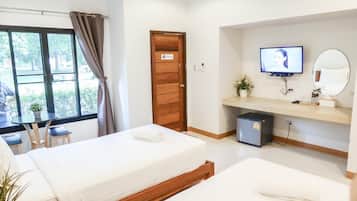A hotel room with two beds, a desk, a television, a mirror, and a small refrigerator.