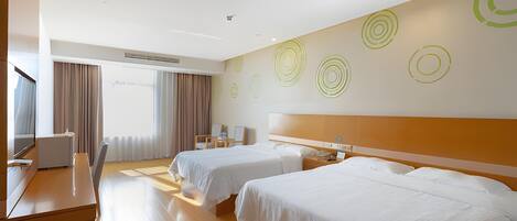 A hotel room with two beds, a desk, a chair, and a large window with curtains.