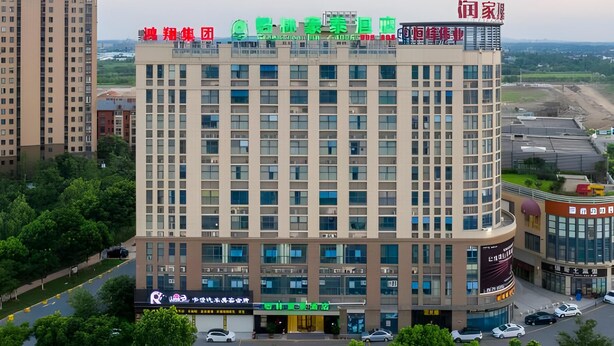 A multi-story hotel with a modern facade, featuring several balconies and a prominent signage at the top. - Greentree Inn Jiaxing Haiyan Passenger Transport Center Hotel (Jiaxing)