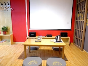 A conference room with a projector screen, a table with a kettle, and two stools. - Shell Xingtai Railway Station South Xinhua Road Hotel (Xingtai)