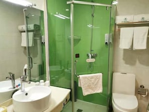A bathroom with a glass-enclosed shower, a sink, and a toilet.