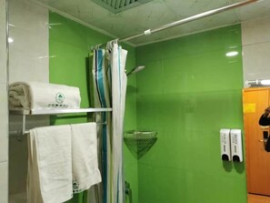 Ein Badezimmer mit grüner Wand, einer Duschkabine und einem Handtuchhalter mit Handtüchern.