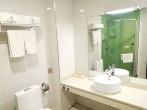 A modern bathroom with two sinks, a glass shower enclosure, and a mirror reflecting the shower area.