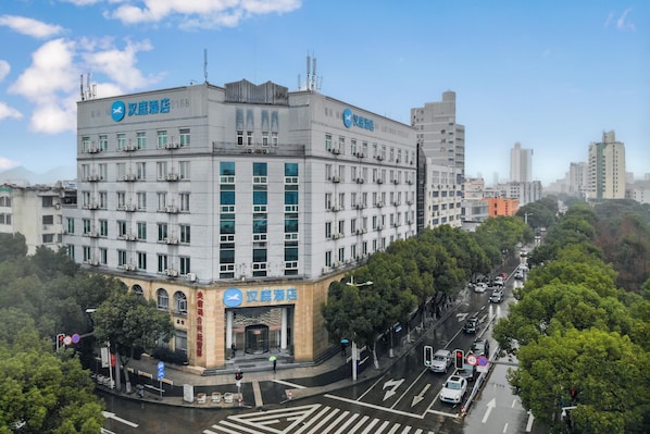 Un hôtel à plusieurs étages, doté d’une enseigne bien visible, situé à un carrefour et donnant sur une rue très fréquentée.