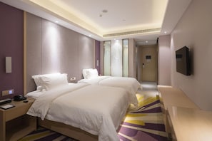A hotel room with two beds, a desk with a phone and a remote, and a television mounted on the wall. - Lavande Hotel (Shenzhen)