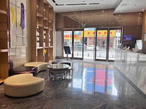 A lobby with a glass door entrance, seating area, and a reception desk. - Lavande Hotel (Shenzhen)