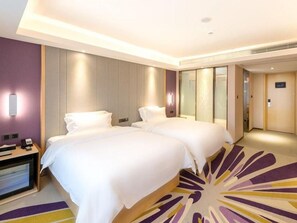A hotel room with two beds, a desk with a chair, and a large window. - Lavande Hotel (Shenzhen)