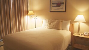 A hotel room with a bed, two bedside lamps, a telephone, and a picture on the wall. - Stratton Mountain Resort (Stratton)