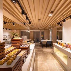 A modern breakfast buffet with wooden display units and a central seating area. - Atour Hotel Kunming South High Speed Railway Station University Town (Kunming)