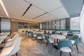 A modern restaurant with a bar area, seating with tables and chairs, and a view through large windows. - Atour Hotel Nankong Quzhou (Quzhou)